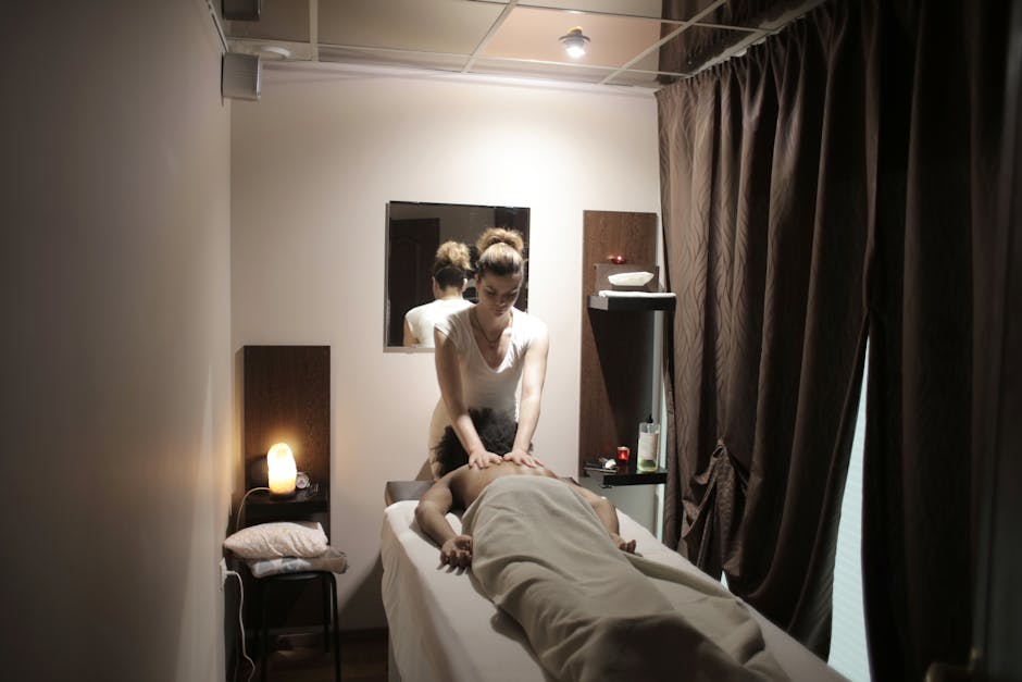 professional masseuse in white uniform massaging shoulders a