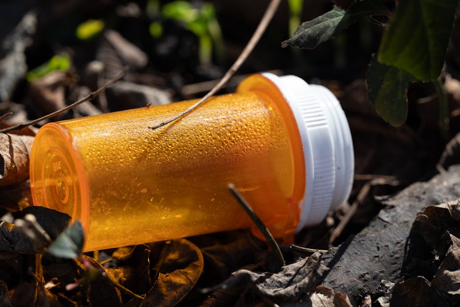 close up of an empty orange pill bottle lying on the ground